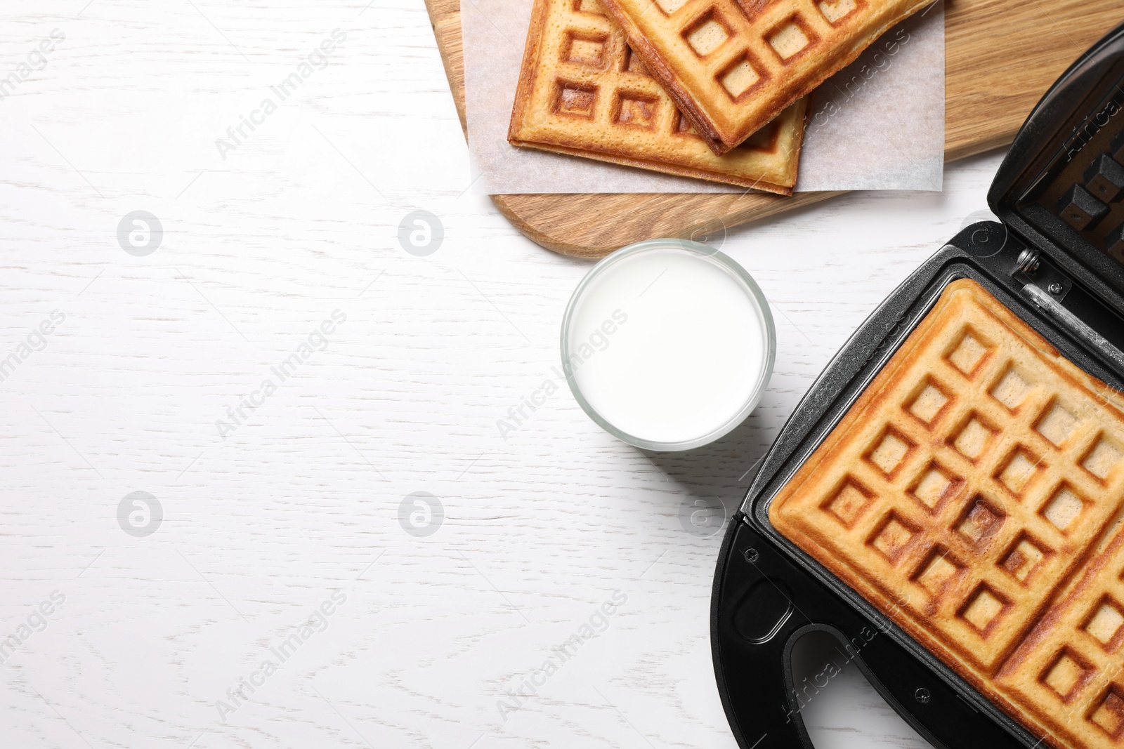 Photo of Flat lay composition with fresh Belgian waffles on white wooden table. Space for text