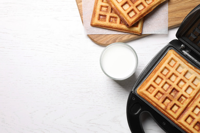 Flat lay composition with fresh Belgian waffles on white wooden table. Space for text