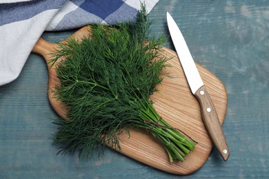 Photo of Bunch of fresh dill on light blue wooden table, flat lay