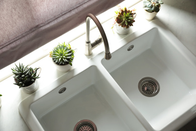 Photo of Houseplants near sink in kitchen, above view. Interior design