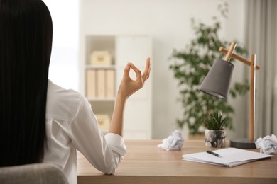 Photo of Woman meditating at workplace, back view. Space for text