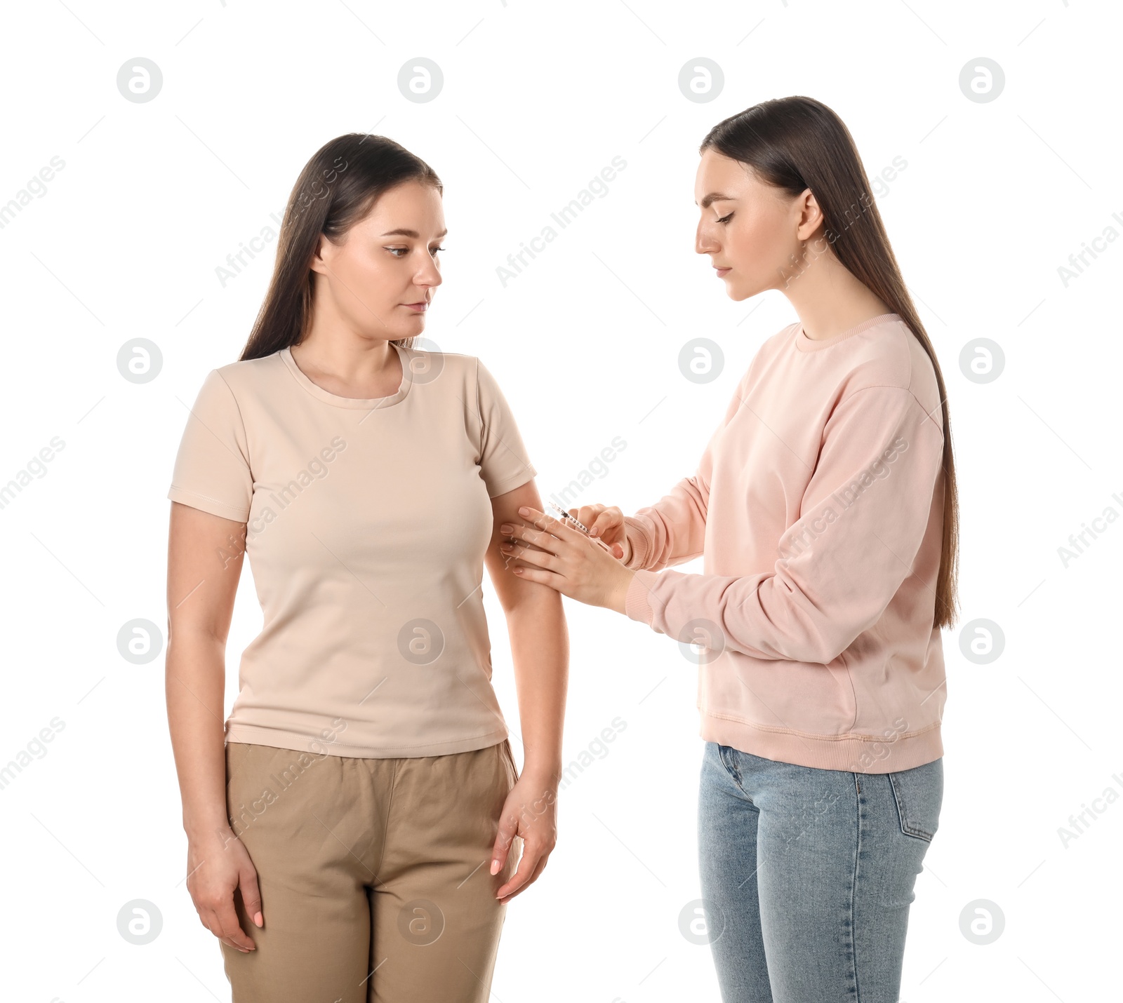 Photo of Woman giving insulin injection to her diabetic friend on white background