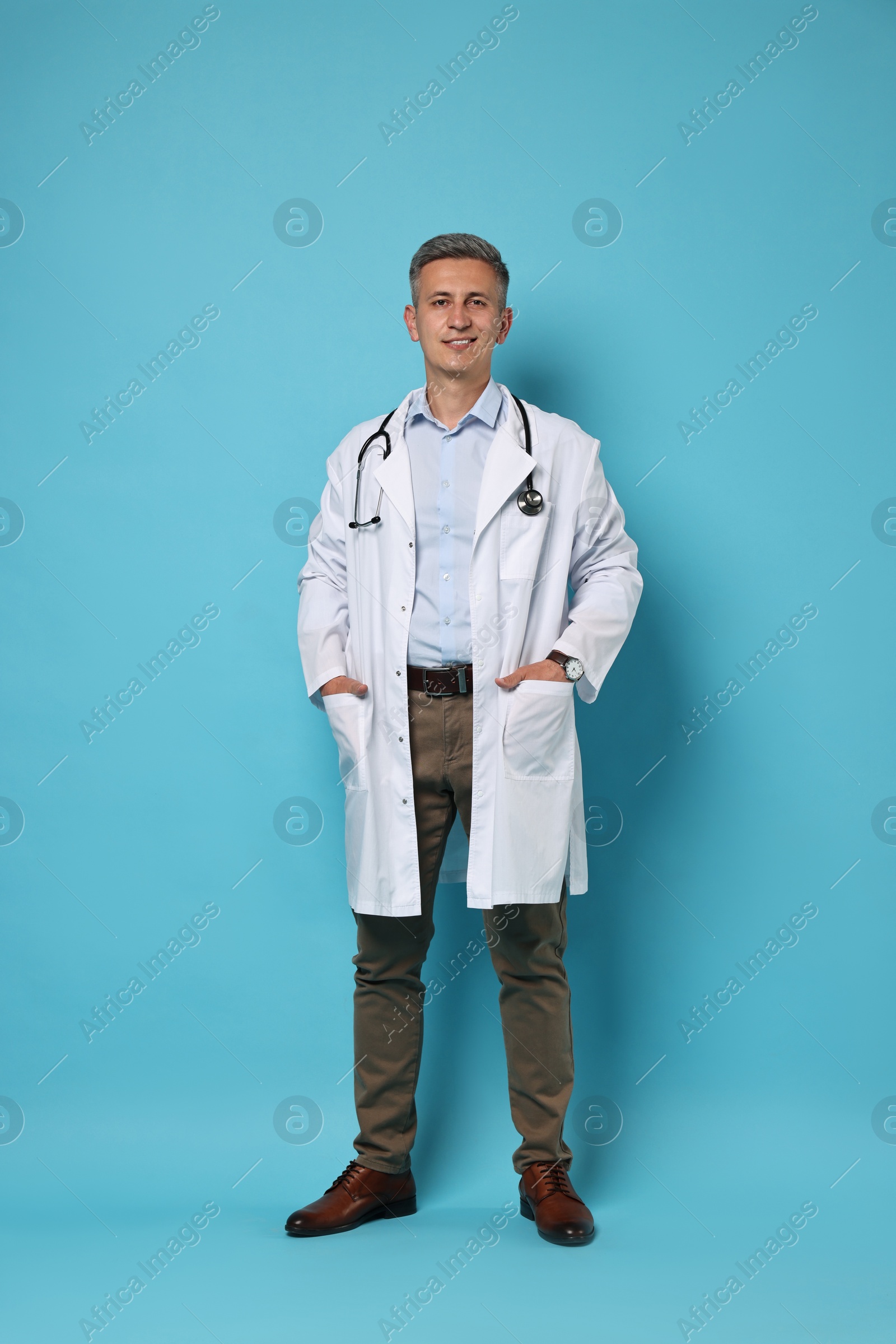 Photo of Doctor with stethoscope on light blue background