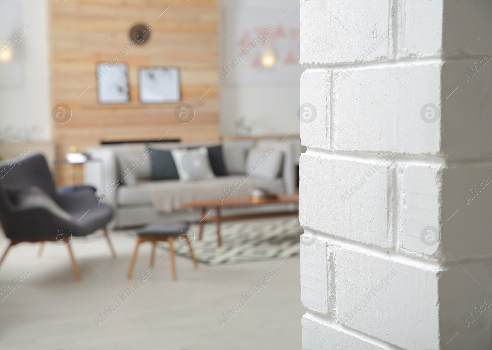 Photo of White brick wall and blurred living room interior on background