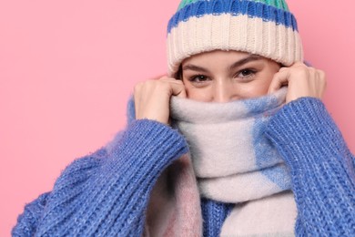 Photo of Beautiful woman in warm scarf and hat on pink background