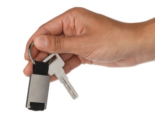 Woman holding key with metallic keychain on white background, closeup