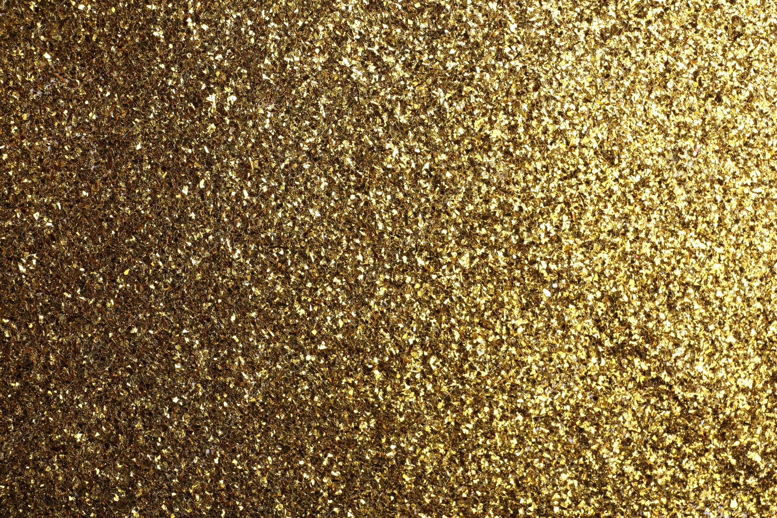 Photo of Beautiful shiny brass glitter as background, closeup