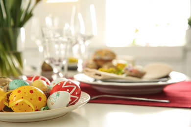 Photo of Festive Easter table setting with decorated eggs, closeup