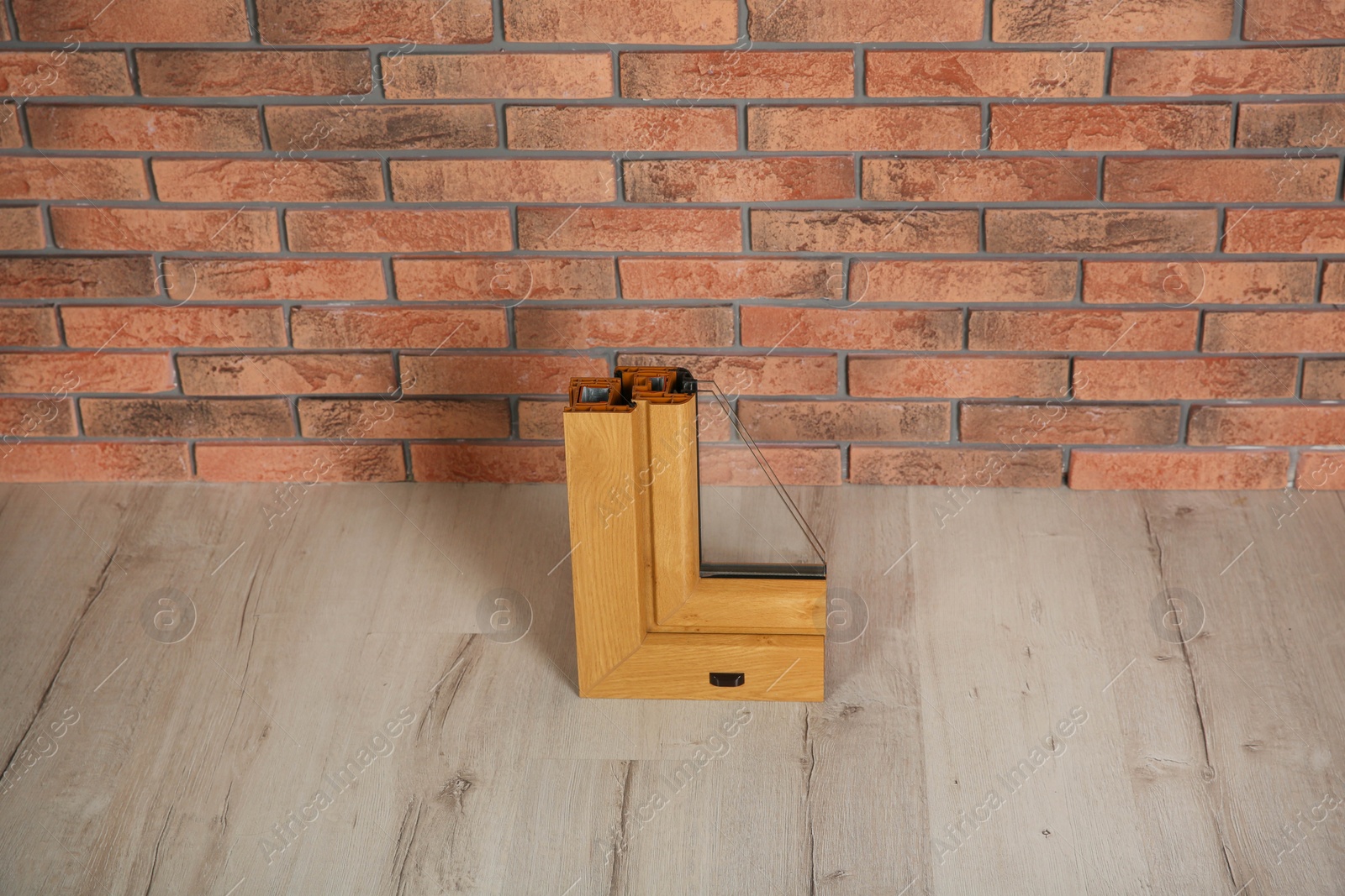 Photo of Sample of modern window profile on floor against brick wall. Installation service