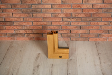 Sample of modern window profile on floor against brick wall. Installation service