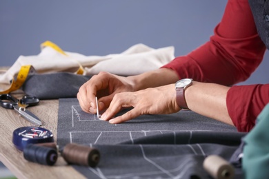 Photo of Tailor working at table in atelier, closeup