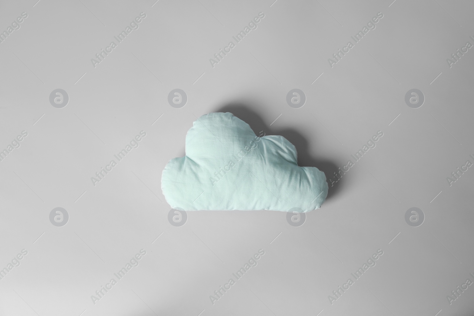 Photo of Soft pillow in shape of cloud on light background