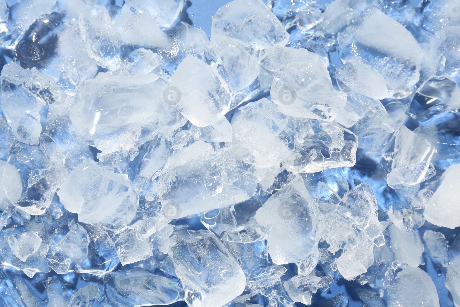 Photo of Pieces of crushed ice on light blue background, above view