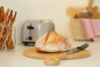 Photo of Loaf of bread and knife on counter in kitchen