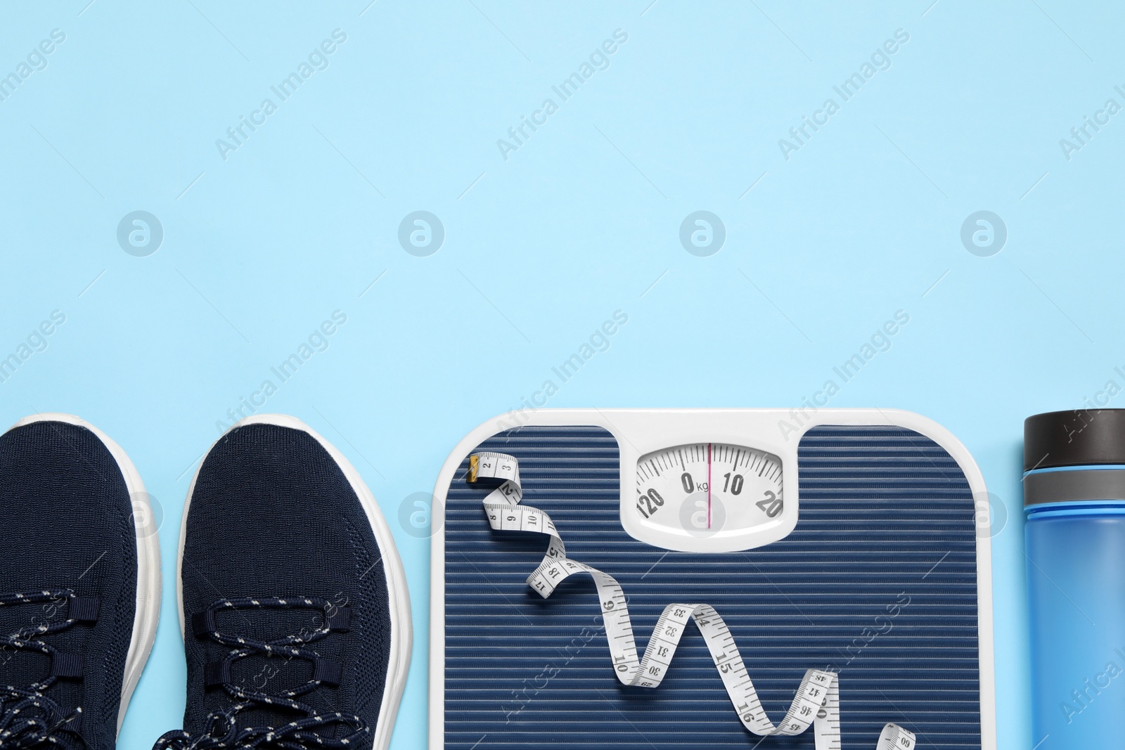 Photo of Weight loss concept. Flat lay composition with sneakers, scales and measuring tape on light blue background, space for text