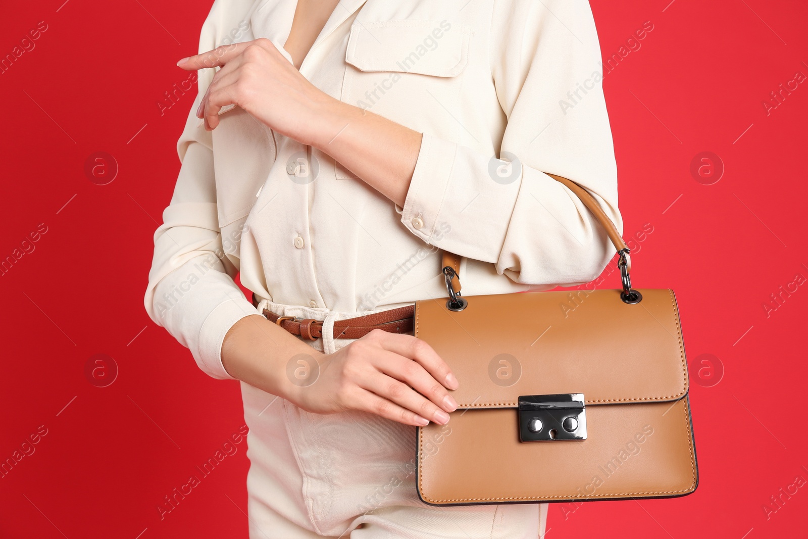 Photo of Young woman in casual outfit with stylish bag on red background, closeup