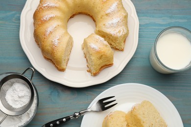 Photo of Delicious sponge cake served on light blue wooden table, flat lay