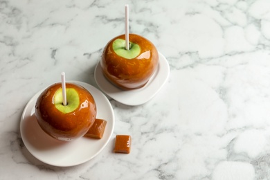 Photo of Delicious green caramel apples on marble table