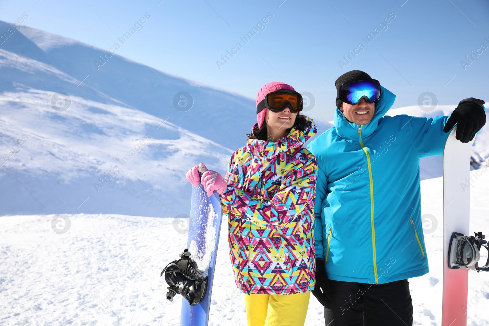 Photo of Couple with snowboards on hill, space for text. Winter vacation