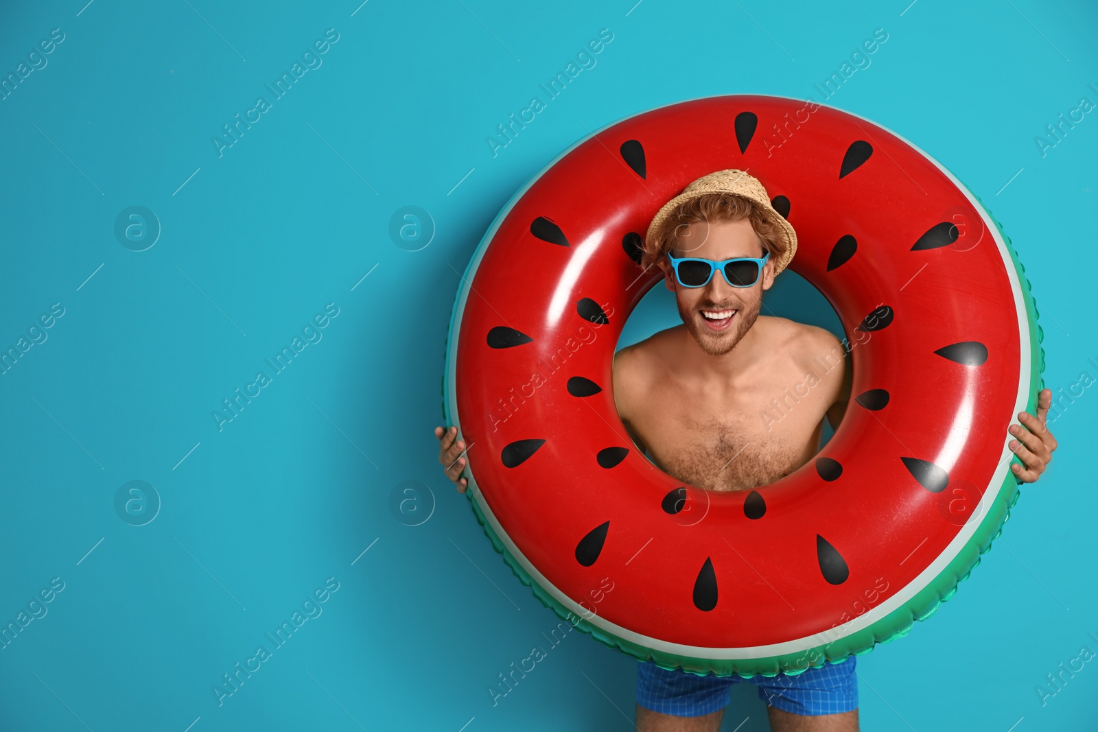 Photo of Happy young man with inflatable ring on color background