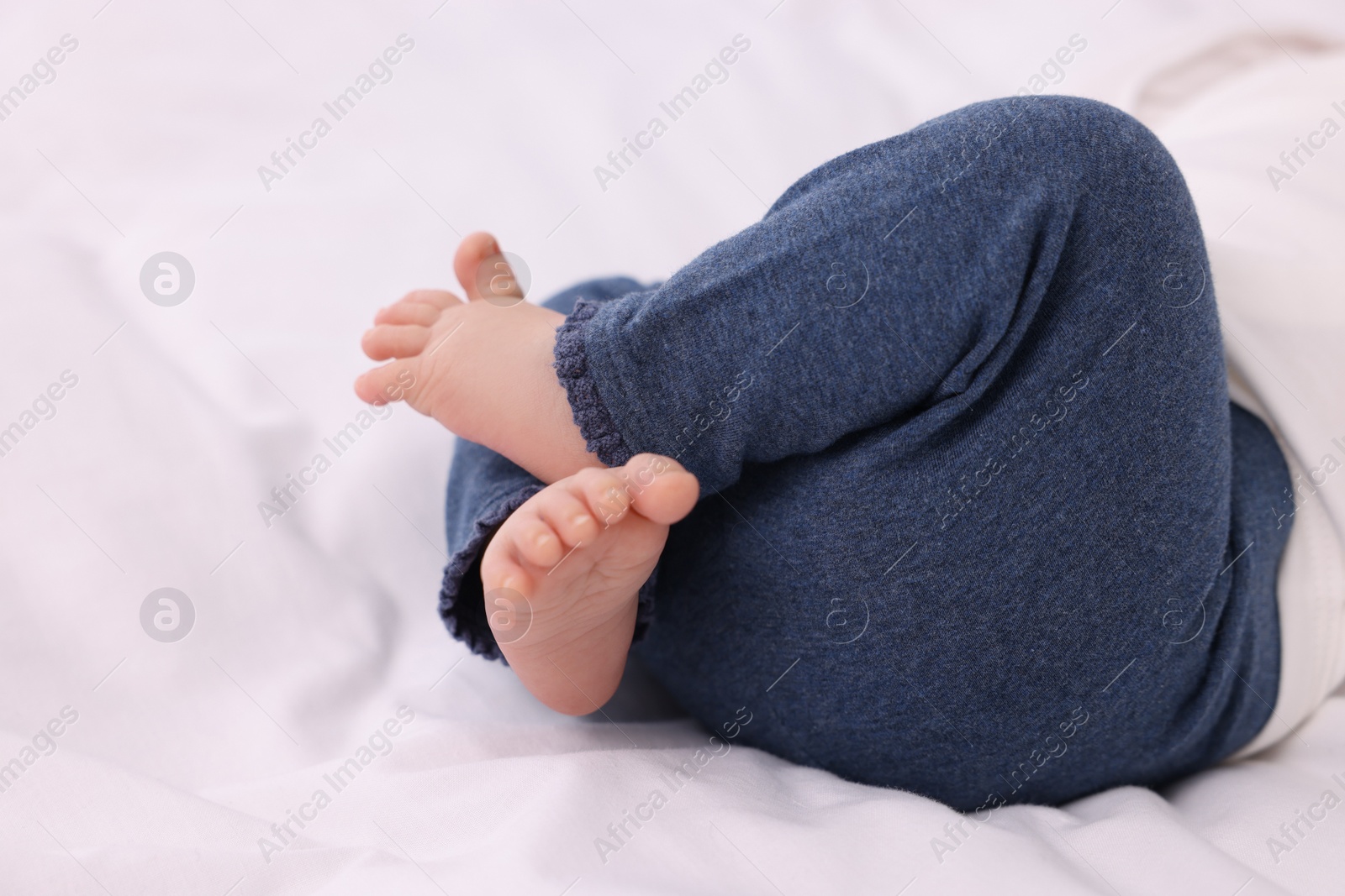 Photo of Newborn baby lying on white blanket, closeup