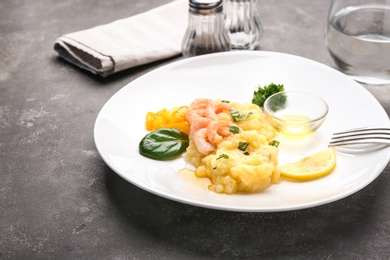 Plate with tasty shrimps and grits on table