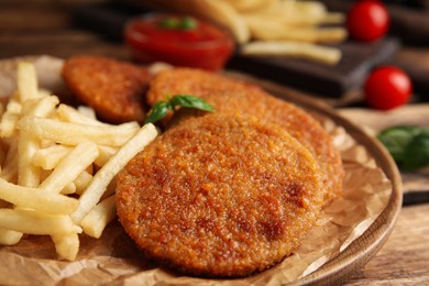 Photo of Delicious fried breaded cutlets served on wooden table, closeup