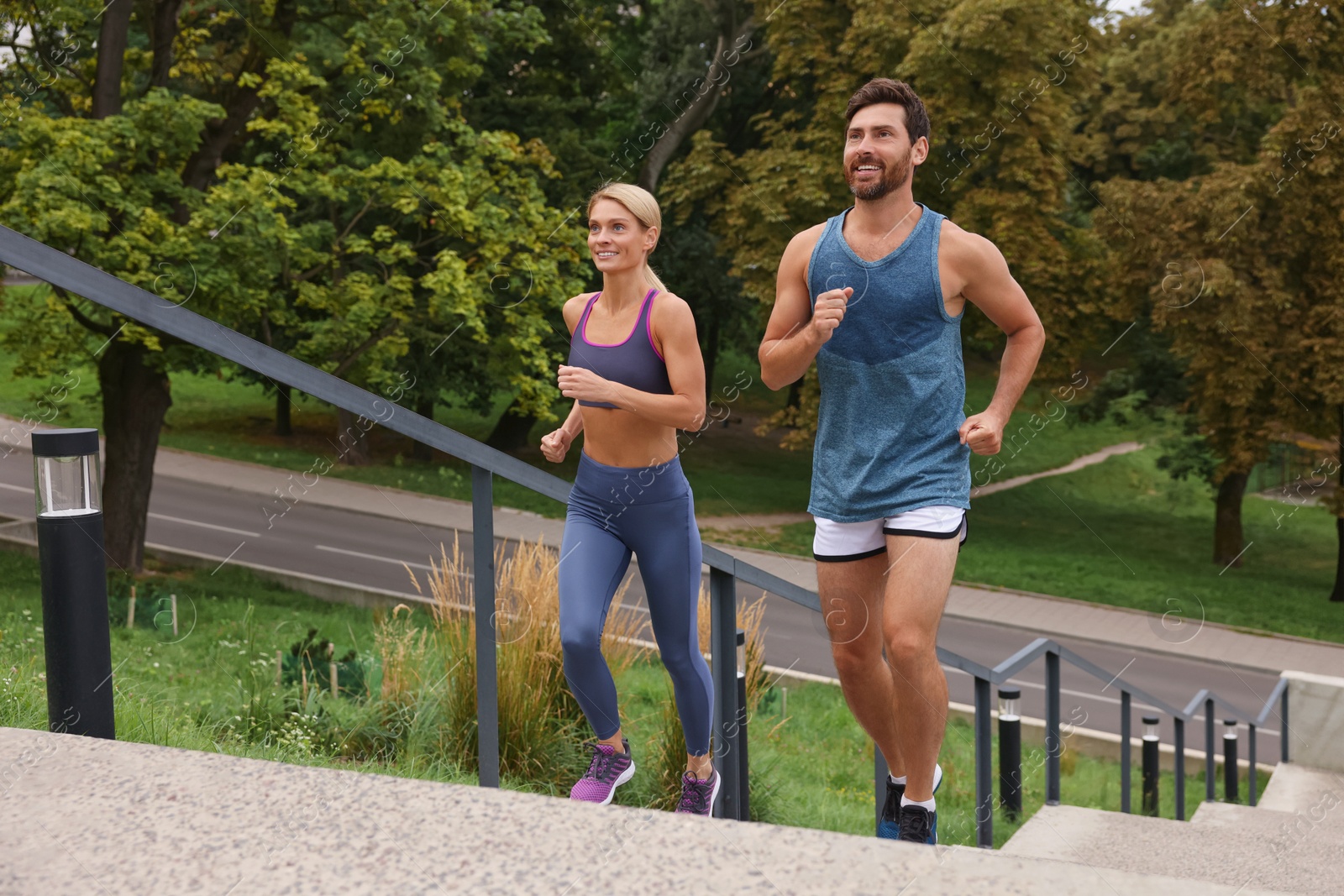 Photo of Healthy lifestyle. Happy couple running up stairs outdoors