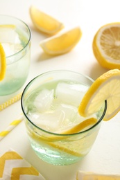 Photo of Soda water with lemon slices and ice cubes on white table