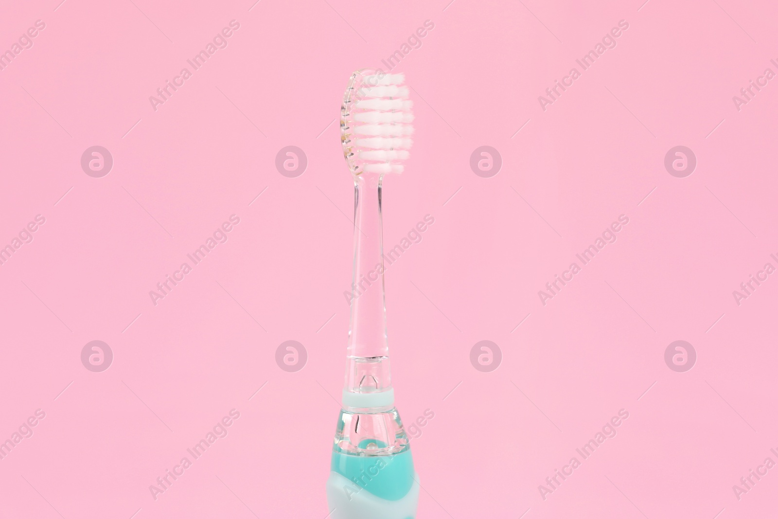 Photo of Electric toothbrush on pink background. Dental care