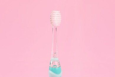 Photo of Electric toothbrush on pink background. Dental care
