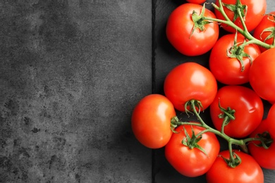 Photo of Slate plate with fresh ripe tomatoes on grey background, top view