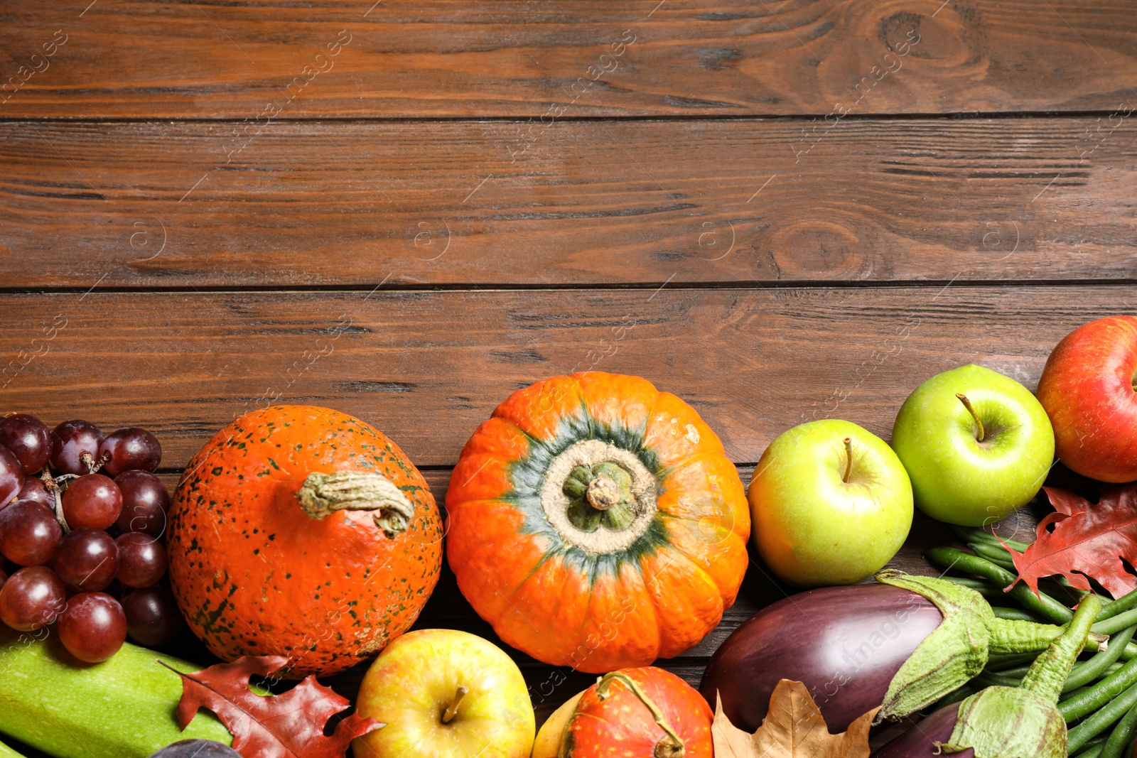 Photo of Flat lay composition with autumn vegetables and fruits on wooden background, space for text. Happy Thanksgiving day