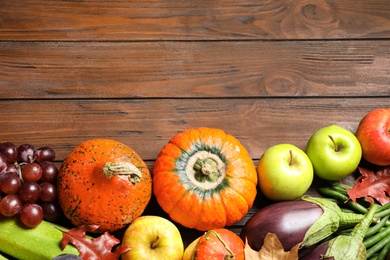 Photo of Flat lay composition with autumn vegetables and fruits on wooden background, space for text. Happy Thanksgiving day