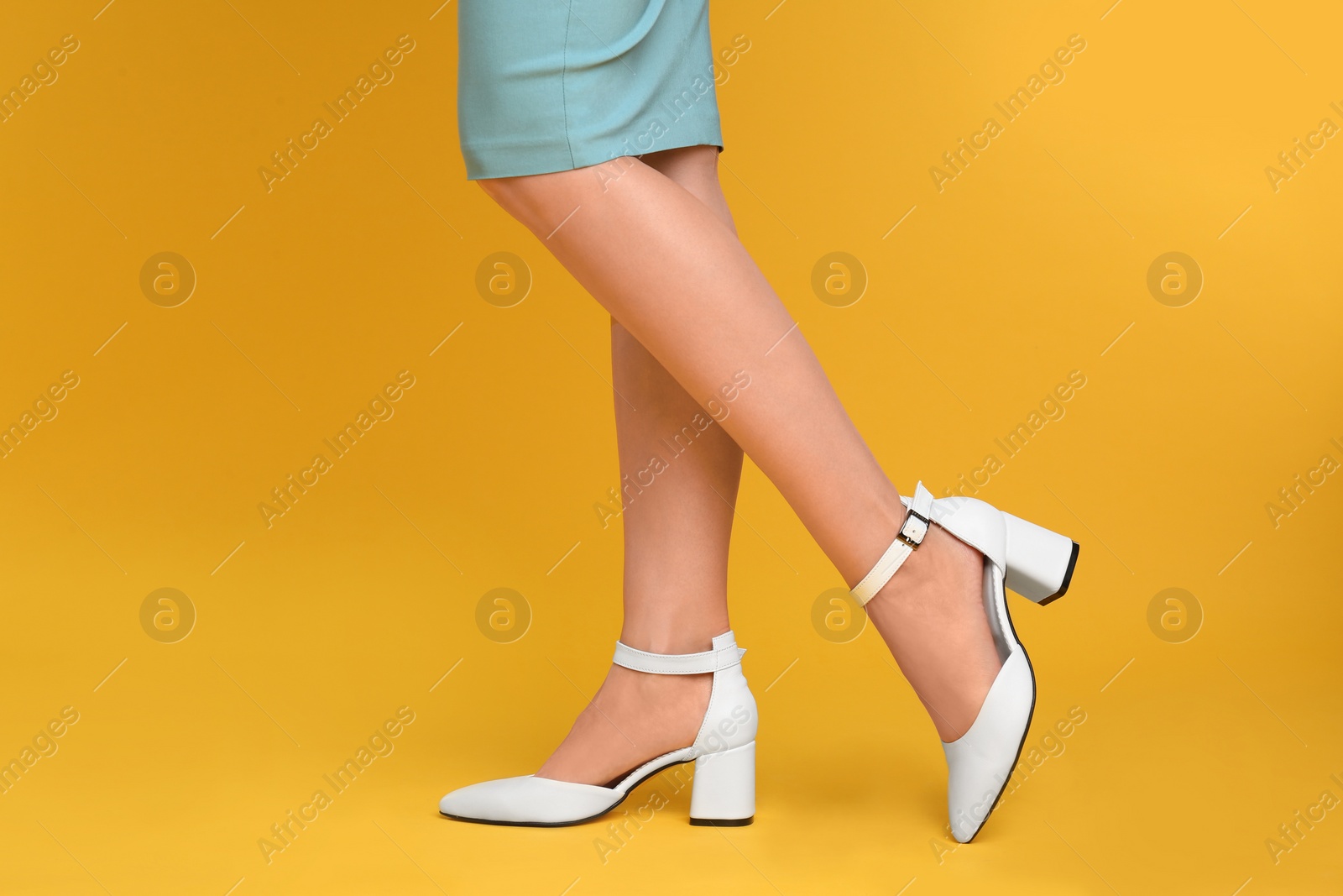 Photo of Woman wearing stylish shoes on yellow background, closeup