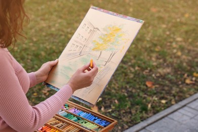 Woman drawing with soft pastels outdoors, closeup