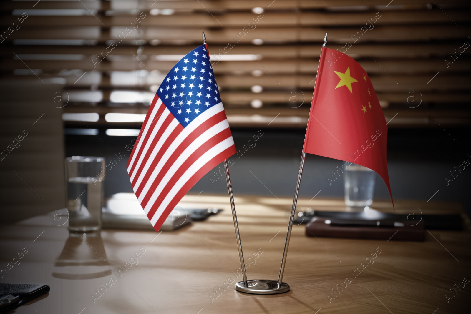 Photo of USA and China flags on wooden table in office. International relations