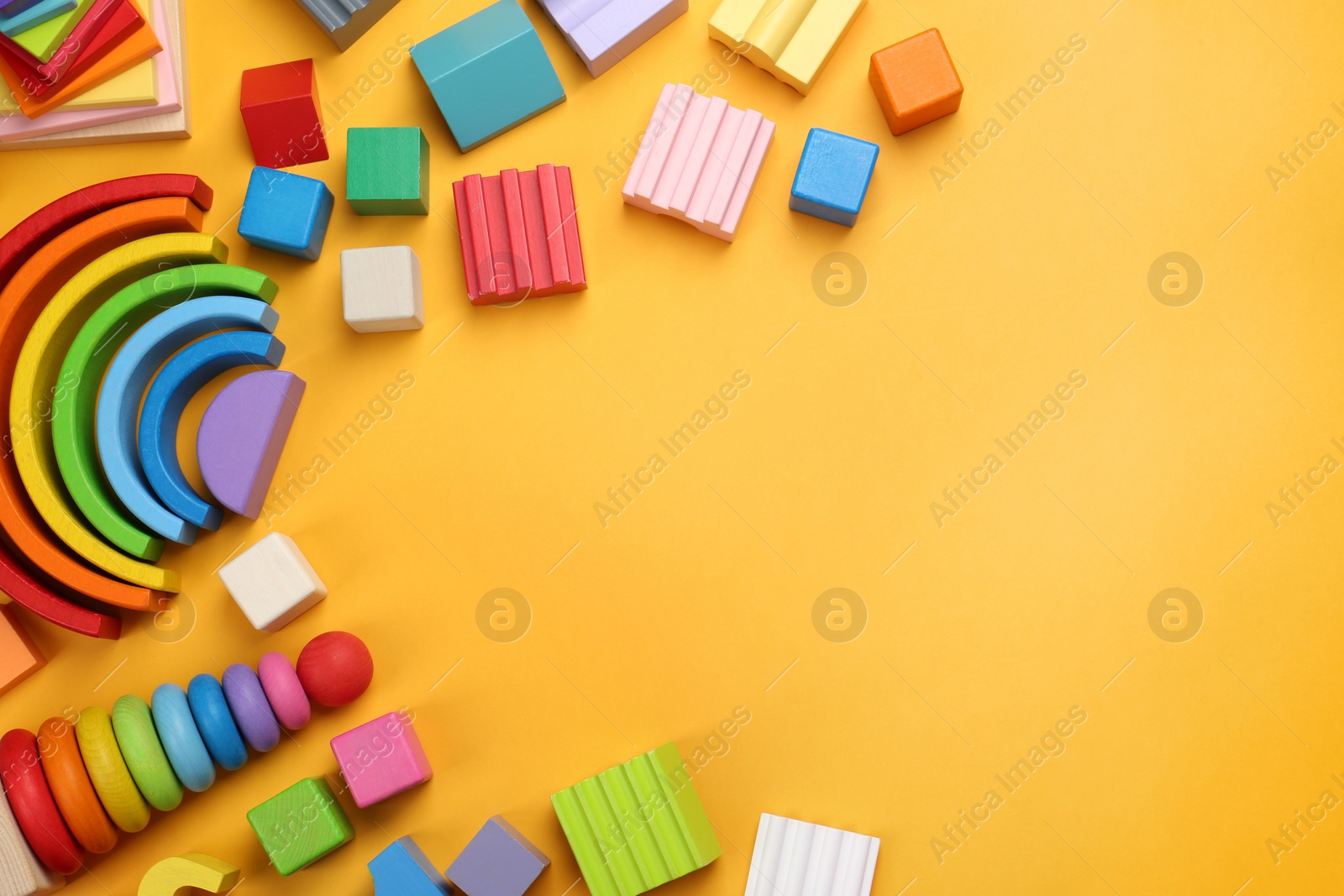 Photo of Different children's toys on yellow background, flat lay. Space for text