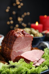 Photo of Delicious ham served with lettuce on plate against blurred festive lights. Christmas dinner