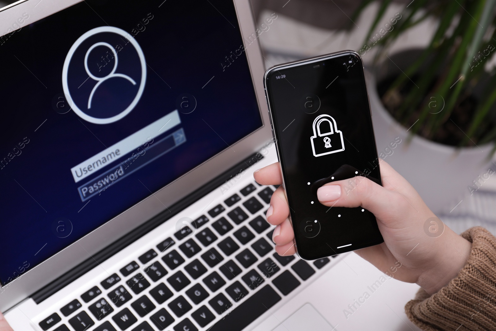 Photo of Woman unlocking smartphone with blocked screen near laptop indoors, closeup