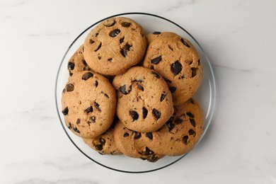 Delicious chocolate chip cookies on white marble table, top view