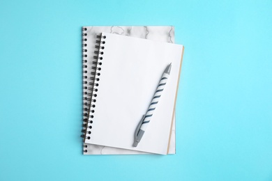 Notebooks and pen on color background, top view