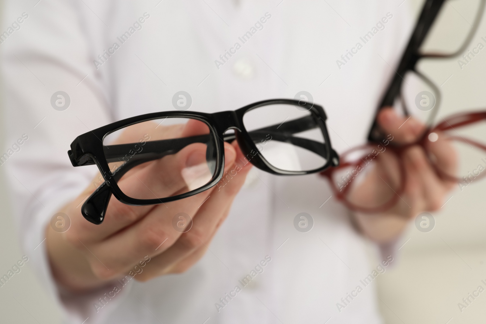 Photo of Woman with different glasses on light background, closeup