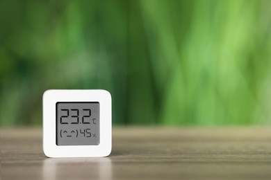 Digital hygrometer with thermometer on table against blurred background. Space for text