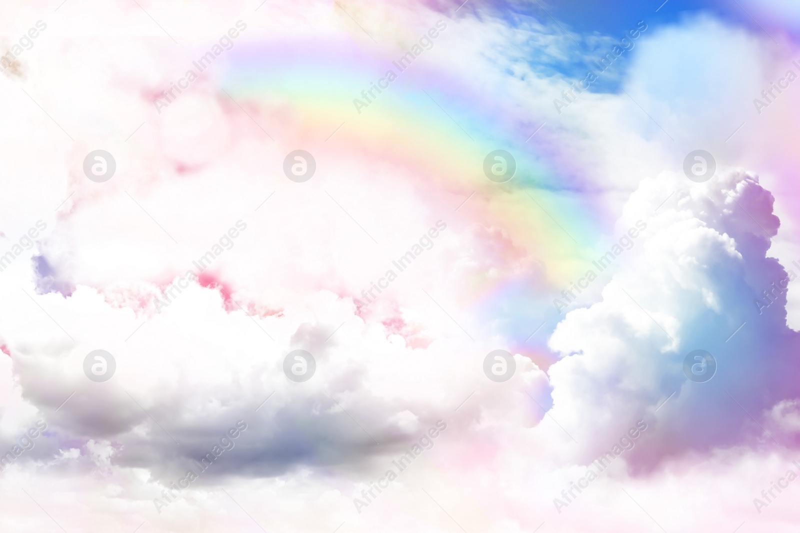 Image of Fantasy world. Beautiful rainbow in sky with fluffy clouds 