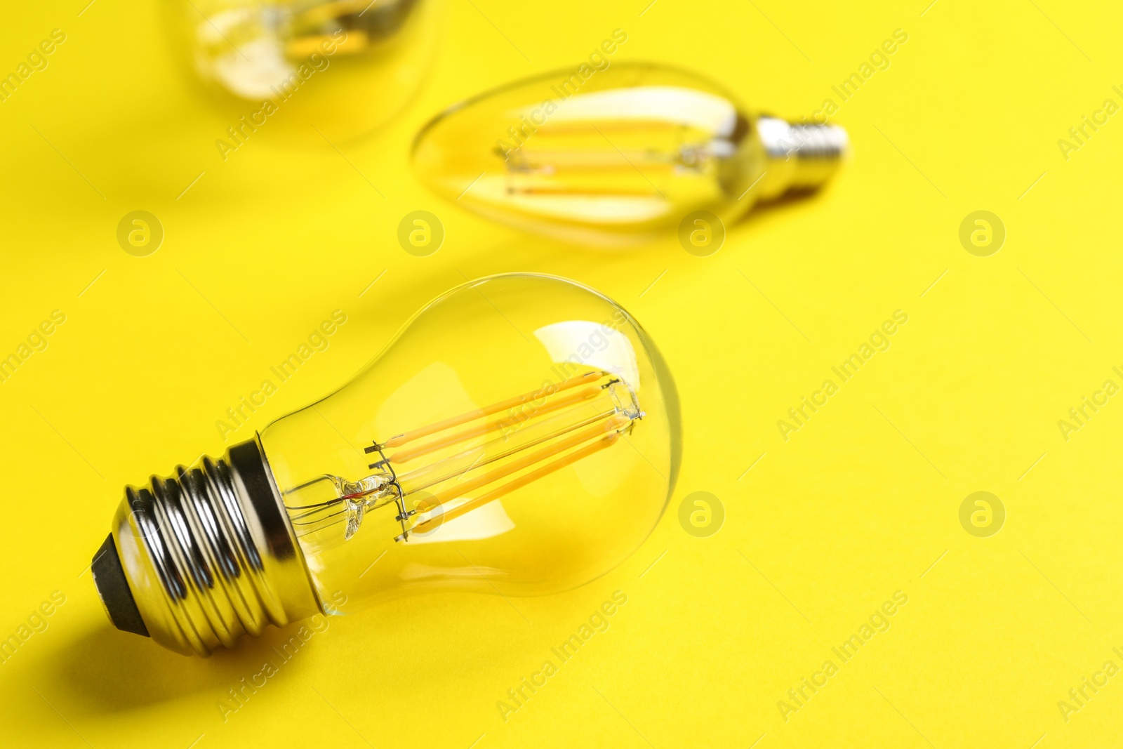 Photo of Vintage lamp bulb on yellow background. Space for text