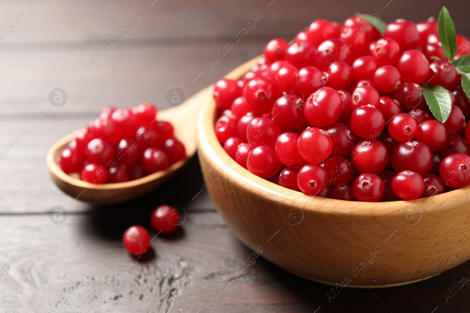 Photo of Fresh ripe cranberry on wooden table, closeup