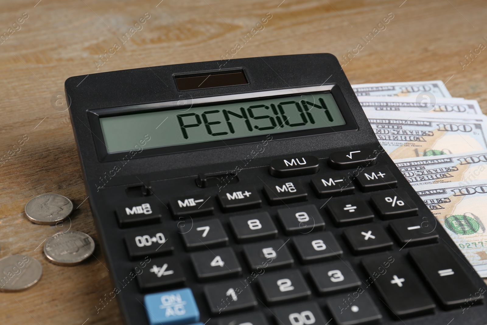 Photo of Coins, dollar banknotes and calculator on wooden table, closeup. Pension planning