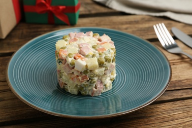 Traditional russian salad Olivier served on wooden table