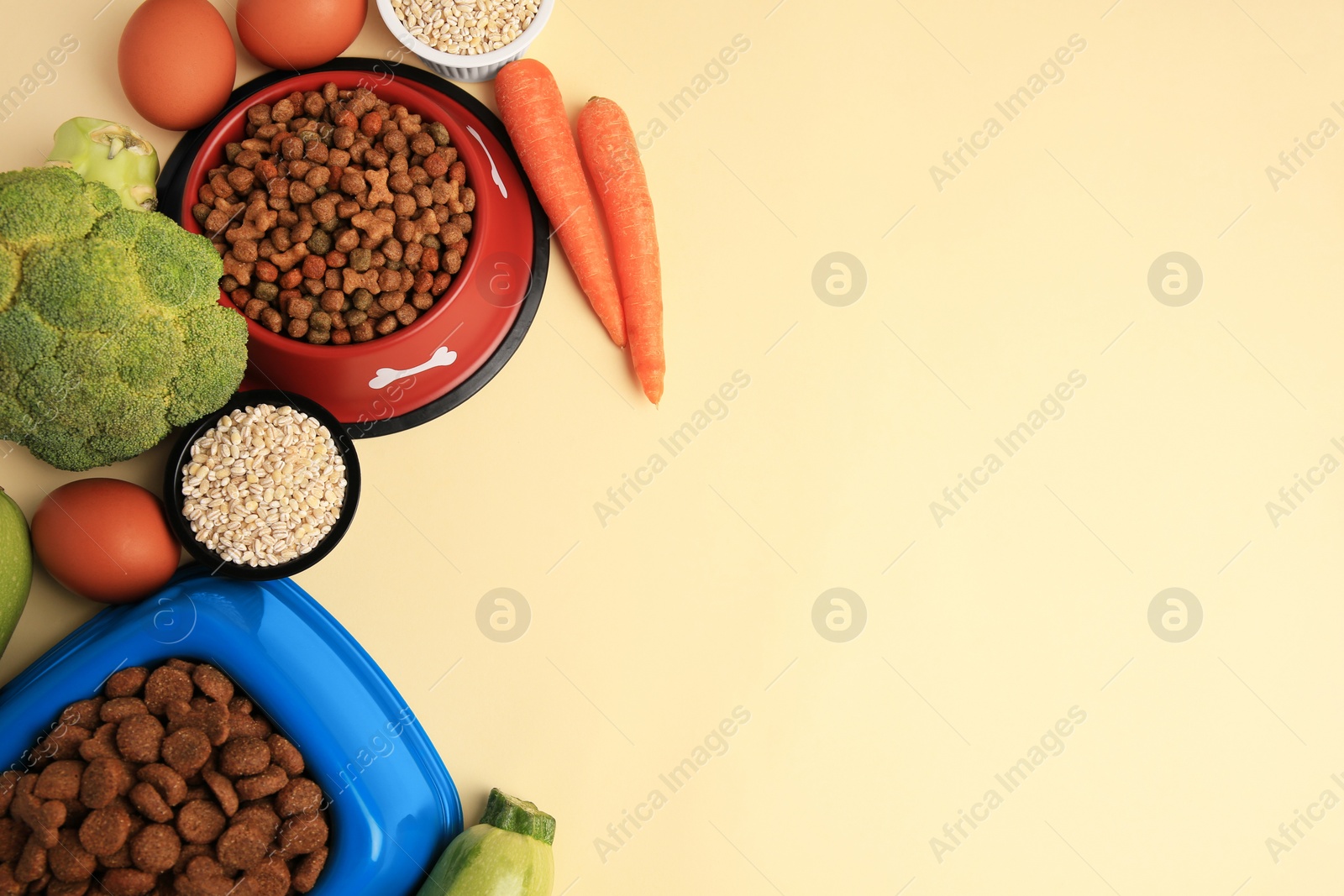 Photo of Dry pet food and products on beige background, flat lay. Space for text